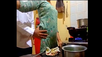 Newly-married-couple indian new married couple romance in kitchen.